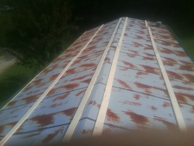Rusted metal roof panels with new wood purlins before replacement — Storm Damage Roof Repair in Nelsonville by Roofing Brothers